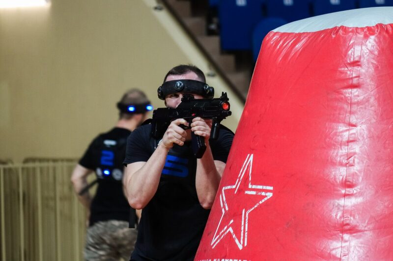 Игрок LASERWAR держит оружие, готовясь к виртуальному бою.